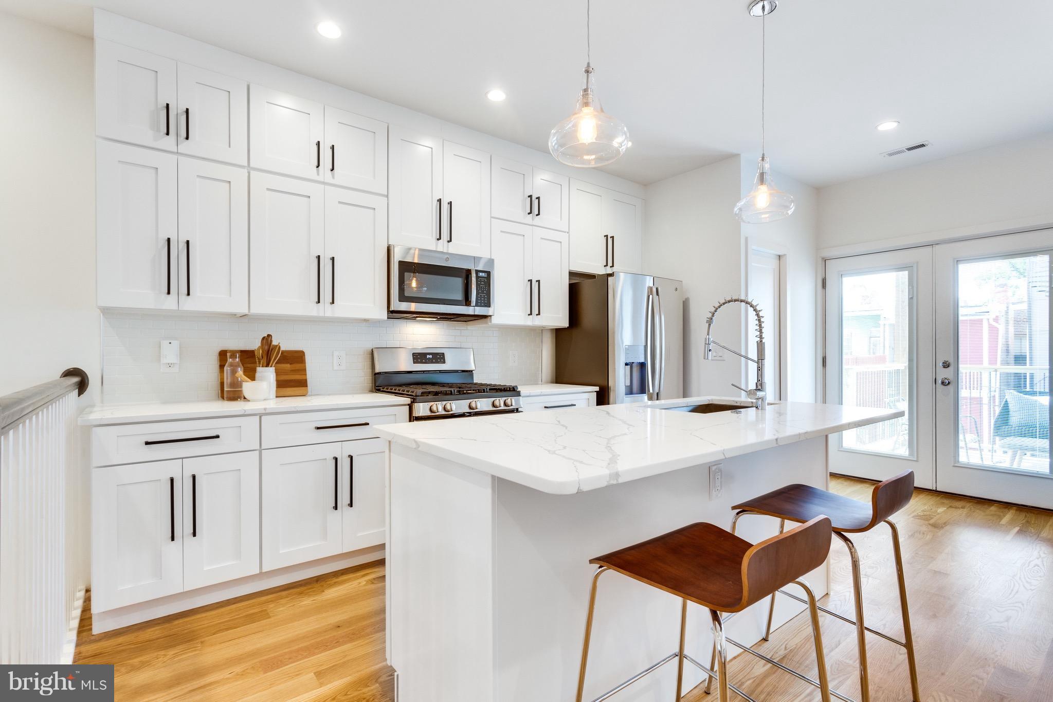 53 R Street Northeast, Unit 2 Washington, DC 20002 - Photo 3 of 25 a kitchen with stainless steel appliances a stove refrigerator sink and cabinets