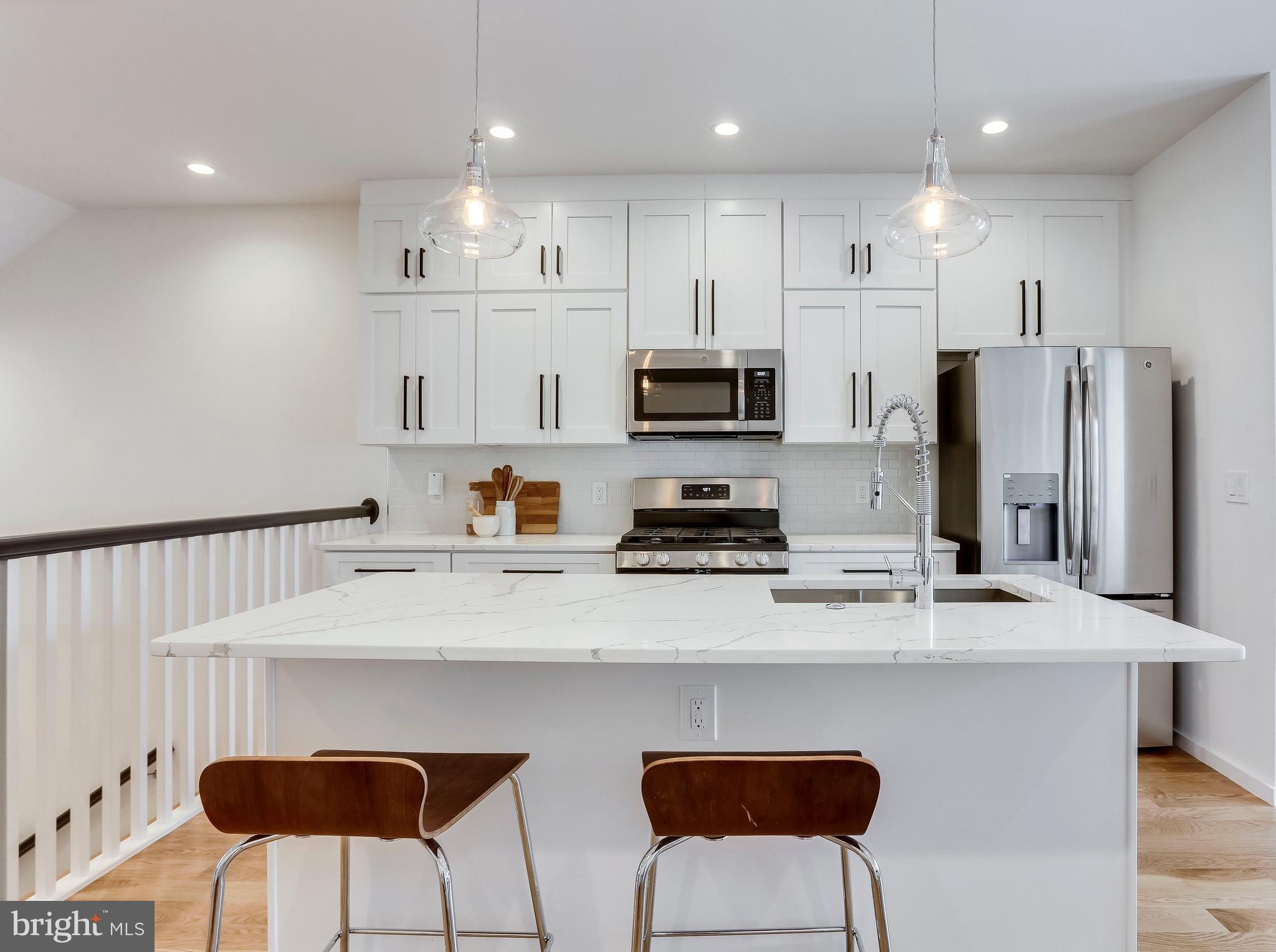 53 R Street Northeast, Unit 2 Washington, DC 20002 - Photo 6 of 25 a kitchen with stainless steel appliances a refrigerator and a stove top oven