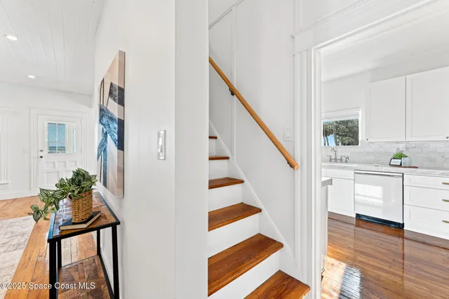 a view of a house with a small yard and flower plants