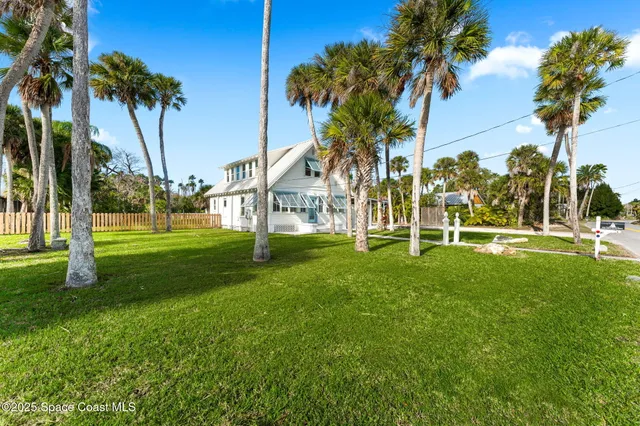an aerial view of a house with a garden and lake view