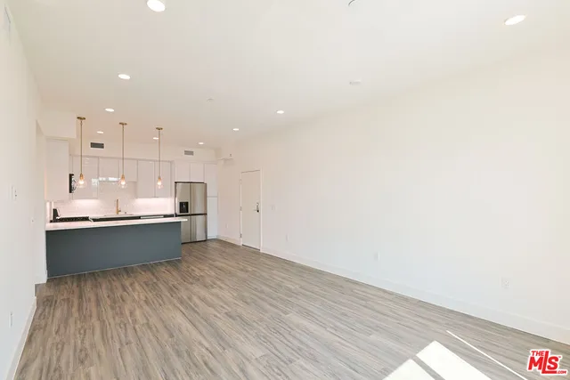 a large kitchen with a lot of counter space and wooden floor