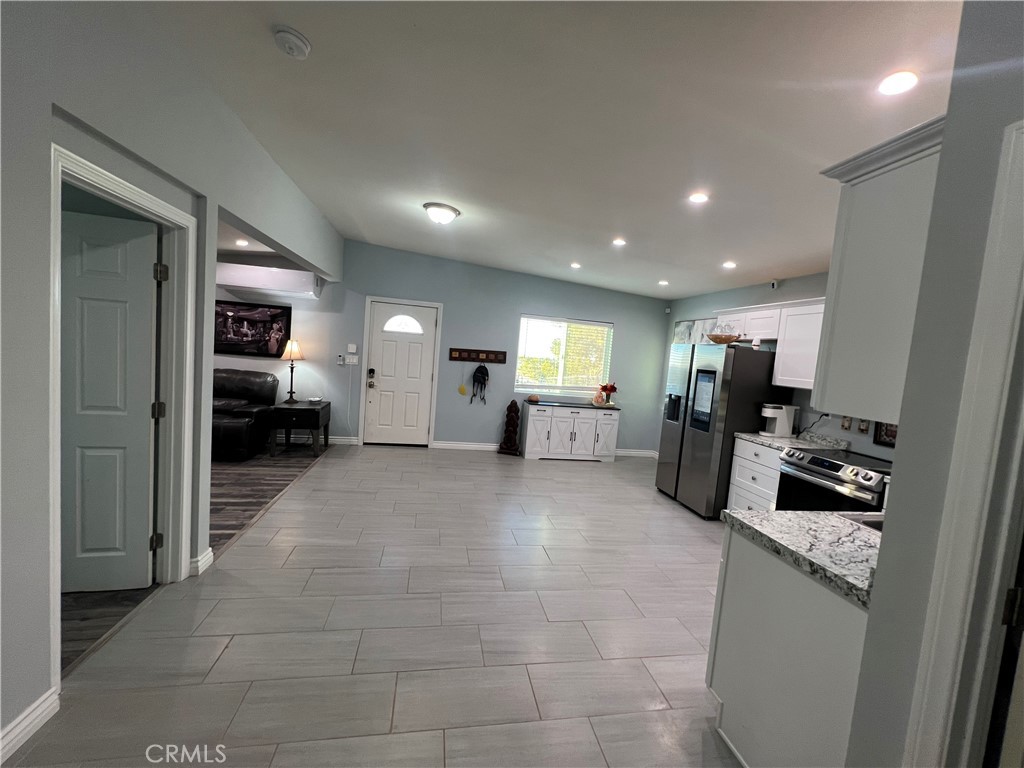 20240 Juniper Road Apple Valley, CA 92308 - Photo 11 of 25 a large hall with stainless steel appliances kitchen island granite countertop a refrigerator and a sink