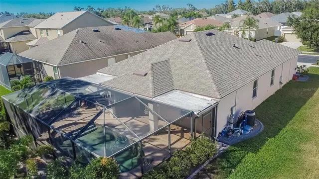 an aerial view of a house with a yard and large tree
