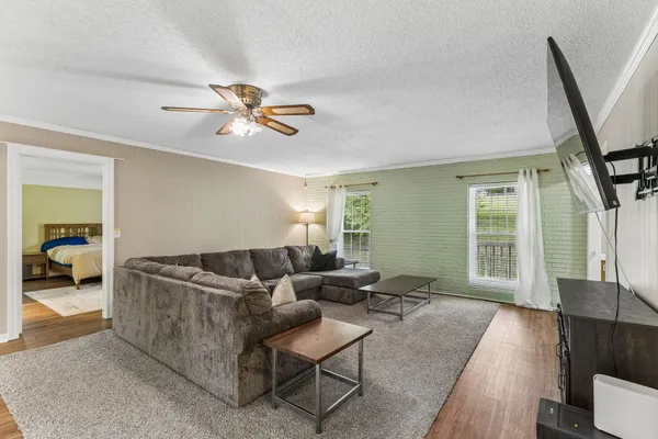 a living room with furniture and a ceiling fan