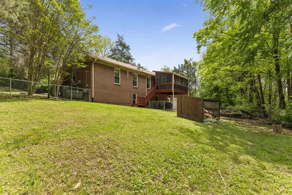 a backyard of a house with large trees and plants