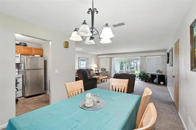 a view of a dining room with furniture a chandelier and wooden floor