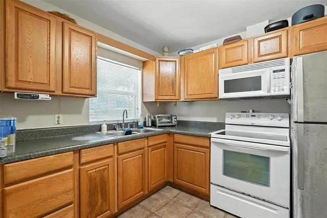 a kitchen with granite countertop cabinets stainless steel appliances and a sink