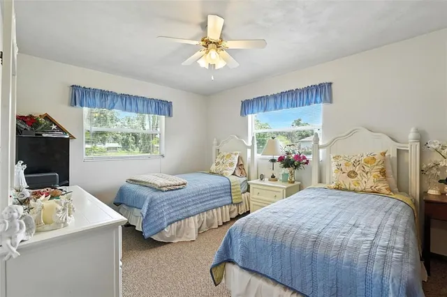a bedroom with a bed and dresser with wooden floor