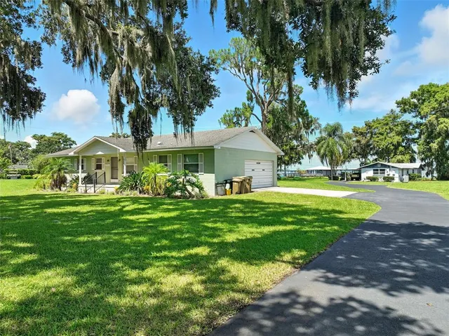 a front view of a house with garden and trees