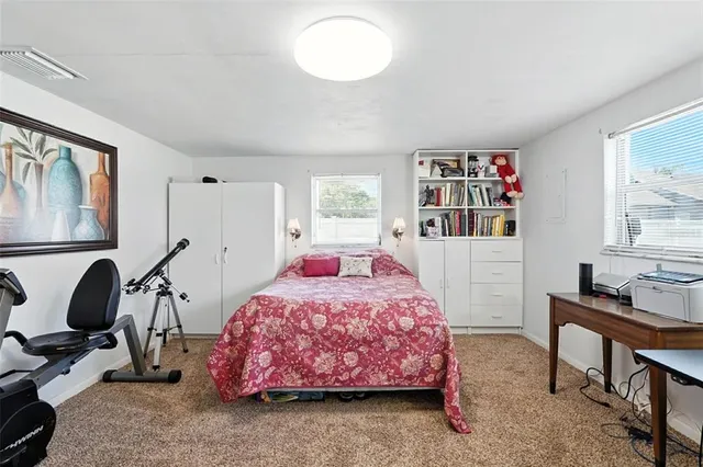 a bedroom with a bed and large windows