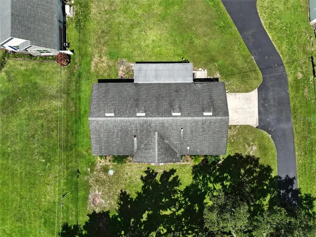 an aerial view of residential houses with outdoor space and trees
