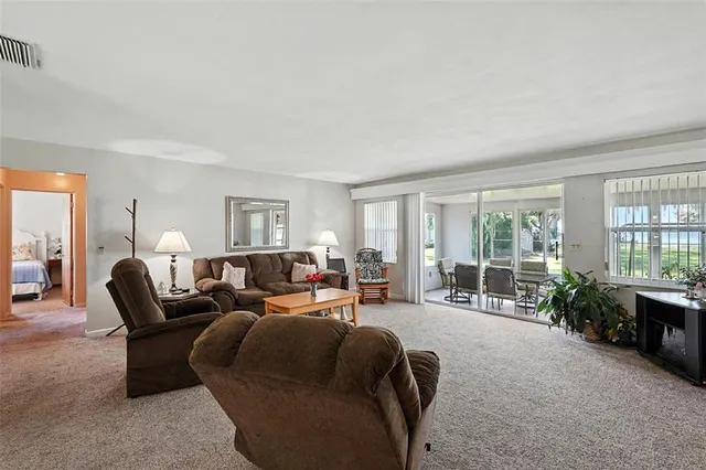 a living room with furniture and large windows