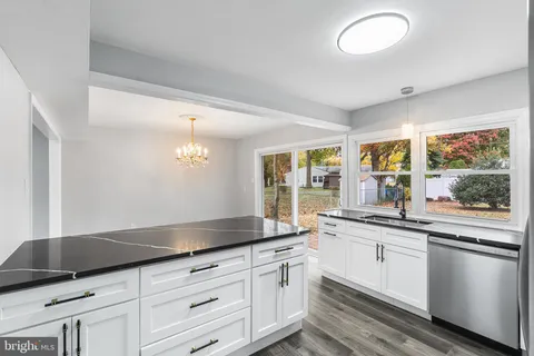 a kitchen with granite countertop white cabinets and white appliances