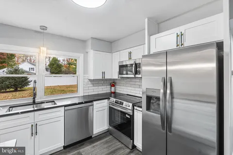 a kitchen with a refrigerator sink and cabinets