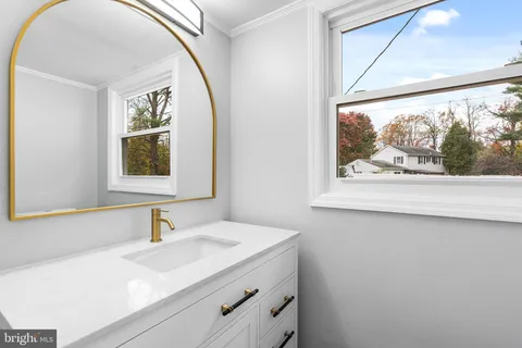 a bathroom with a granite countertop sink and a large mirror