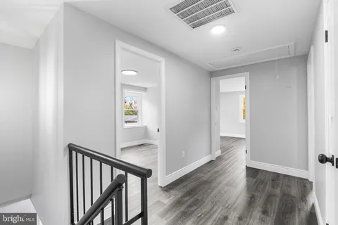 a view of a hallway with wooden floor and stairs