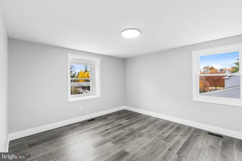 an empty room with a window and wooden floor