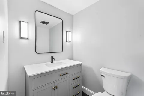 a bathroom with a toilet sink and mirror