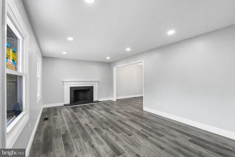 a view of empty room with wooden floor and fireplace