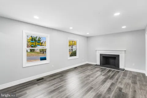 an empty room with window and fireplace