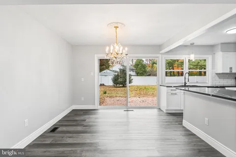 a view of a kitchen with granite countertop a stove and a sink