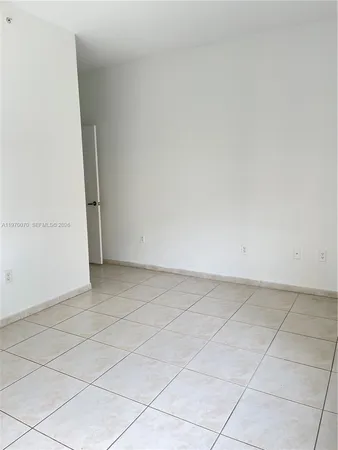 a view of a room with a white wall and tiles