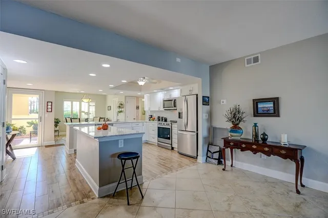 a living room with furniture and a dining table with kitchen view