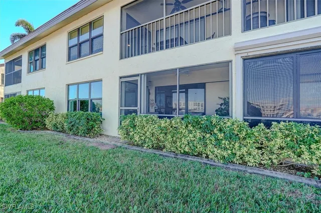 a view of a house with brick walls and a yard with plants