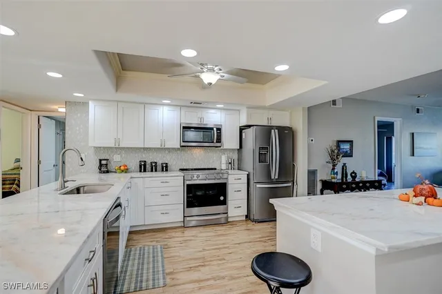 a kitchen with stainless steel appliances granite countertop a sink refrigerator and cabinets