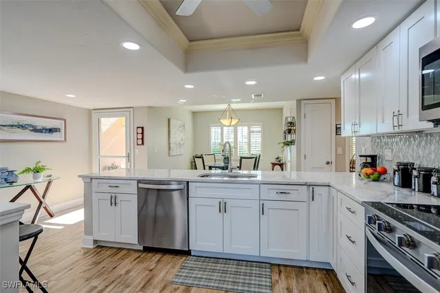 a kitchen with white cabinets and appliances