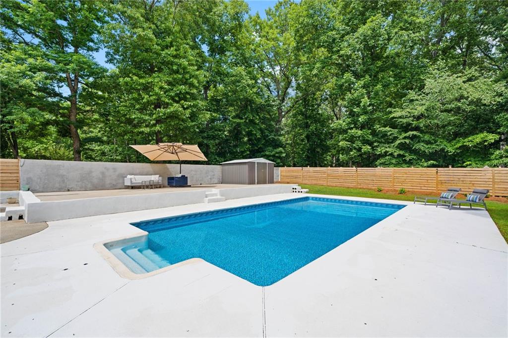 4205 South Berkeley Lake Road Northwest Berkeley Lake, GA 30096 - Photo 24 of 34 a view of a swimming pool and trees