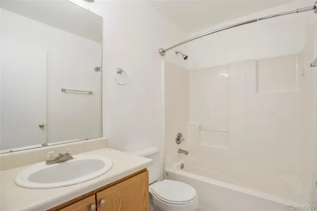 a bathroom with a sink toilet tub vanity and shower