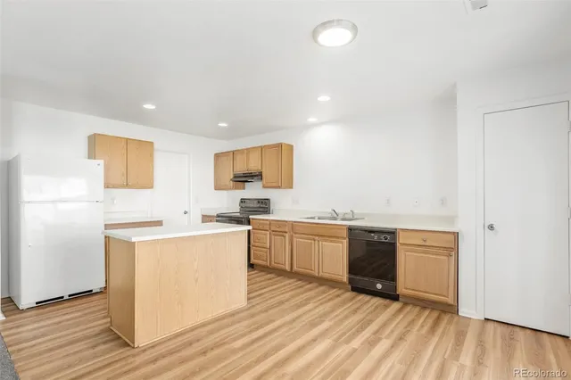 a kitchen with cabinets a sink and wooden floor