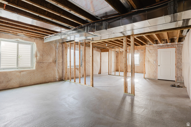 433 North 600 West Smithfield, UT 84335 - Photo 40 of 40 Unfinished lower level with concrete flooring, framed interior walls, multiple windows with horizontal blinds, exposed ceiling joists, and a white interior door