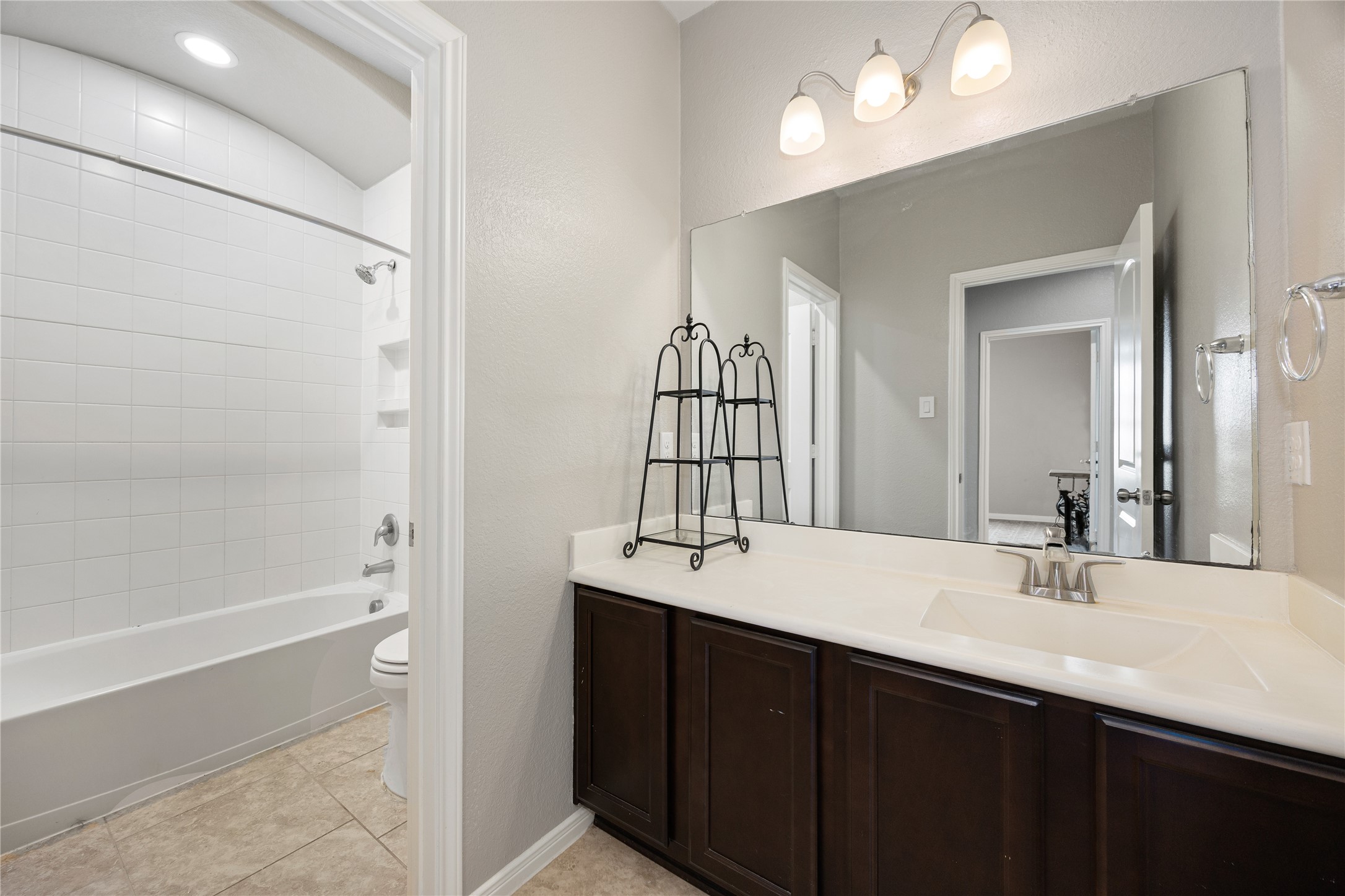 14023 Beaverhead Range Court Conroe, TX 77384 - Photo 18 of 29 Welcome to a crisp and clean secondary bathroom, offering both style and functionality for family and guests. This bright space features a well-appointed vanity area and a classic tub/shower combo.