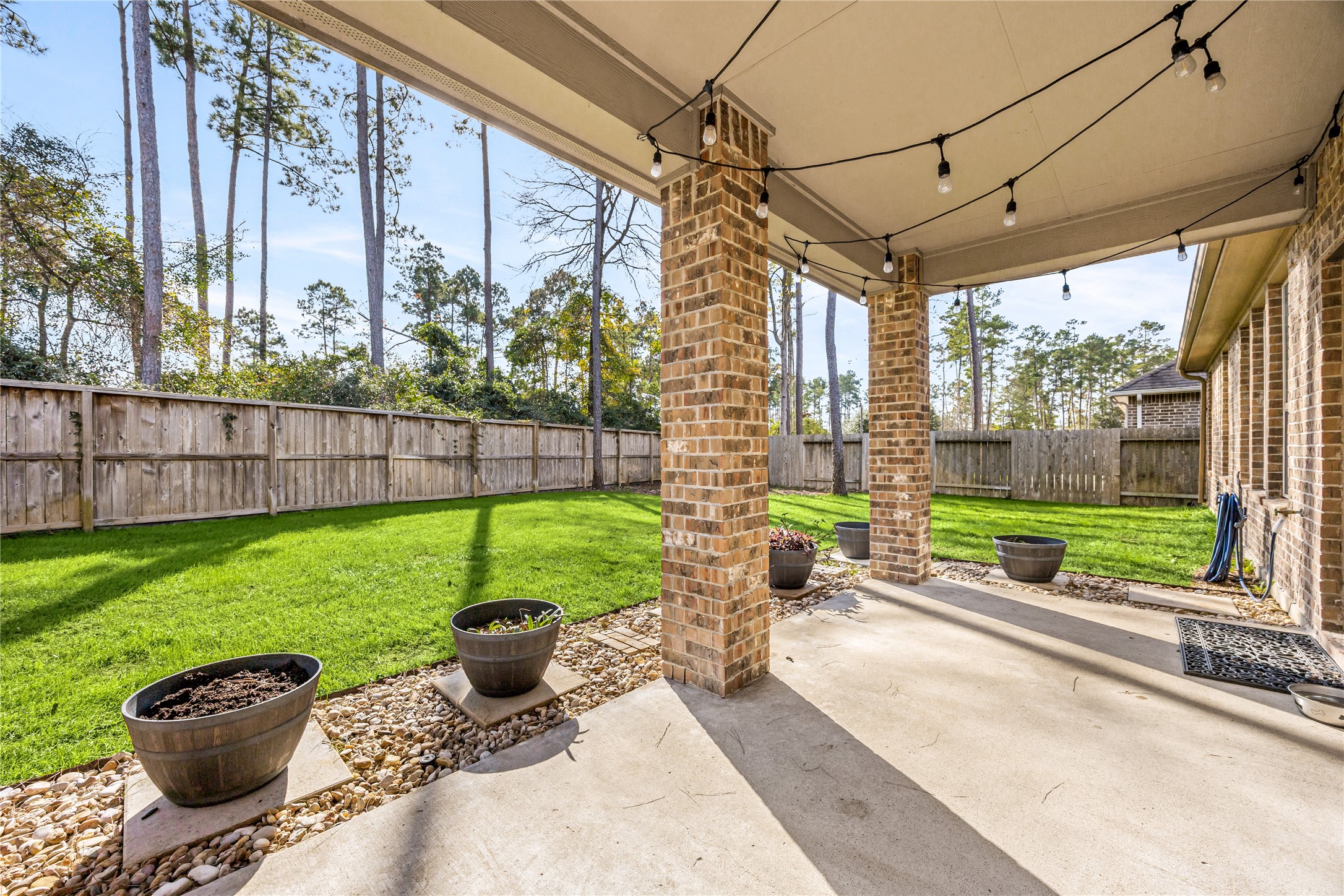 14023 Beaverhead Range Court Conroe, TX 77384 - Photo 21 of 29 Step outside to your private outdoor oasis! This beautifully designed covered patio and spacious backyard provide the perfect retreat for relaxation, entertaining, or simply enjoying the beautiful weather.