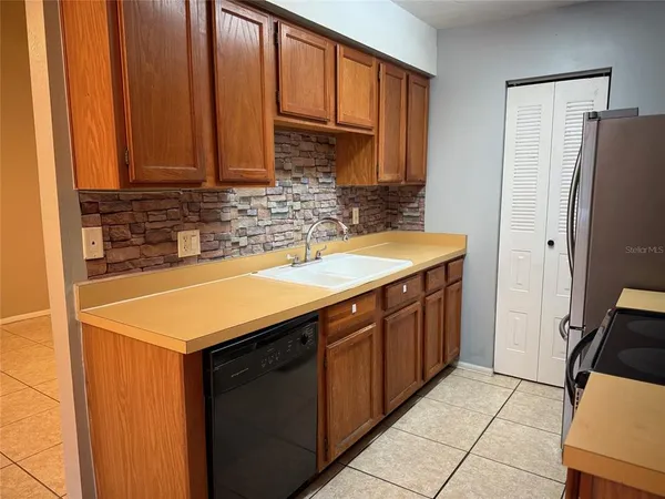 a kitchen with stainless steel appliances granite countertop a sink and a refrigerator