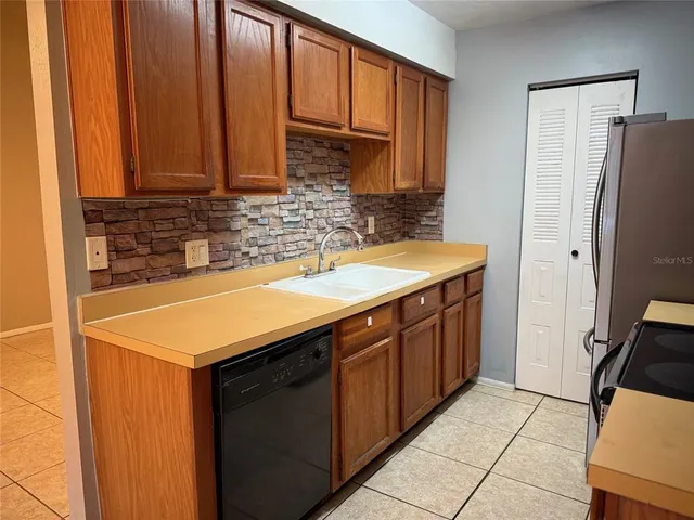 a kitchen with stainless steel appliances granite countertop a sink and a refrigerator