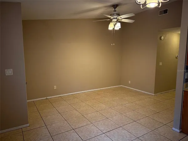 an empty room with a ceiling fan and carpet