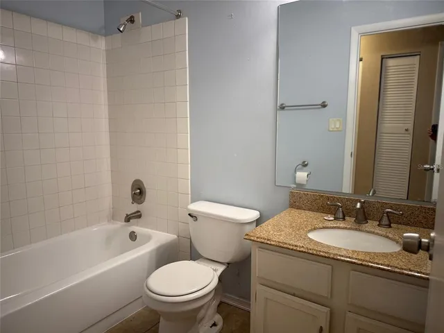 a bathroom with a granite countertop toilet a sink and a bathtub
