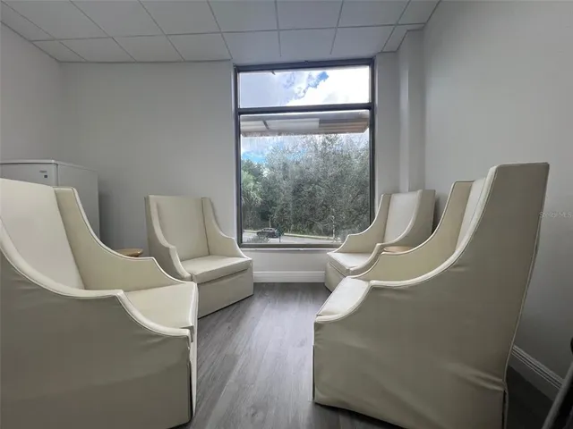 a living room with furniture a large window and a chandelier