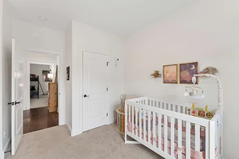 a view of a bedroom with wooden floor & windows