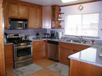 4352 Goodson Way Rohnert Park, CA 94928 - Photo 2 of 9 a kitchen with stainless steel appliances granite countertop a sink a stove a microwave and wooden cabinets
