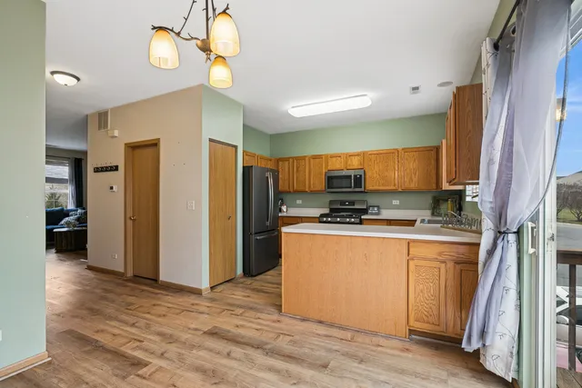 a kitchen with stainless steel appliances granite countertop a refrigerator a stove and a sink with granite countertops