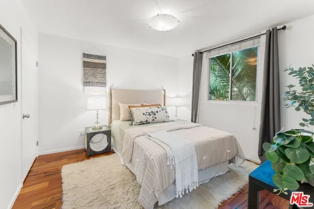 a bedroom with a bed window and a potted plant