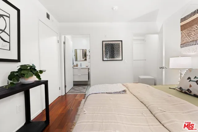 a bedroom with a bed and a painting on the wall