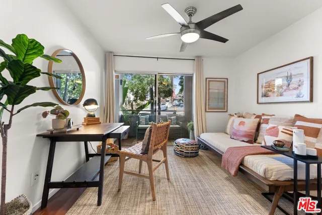 a living room with furniture a window and a potted plant