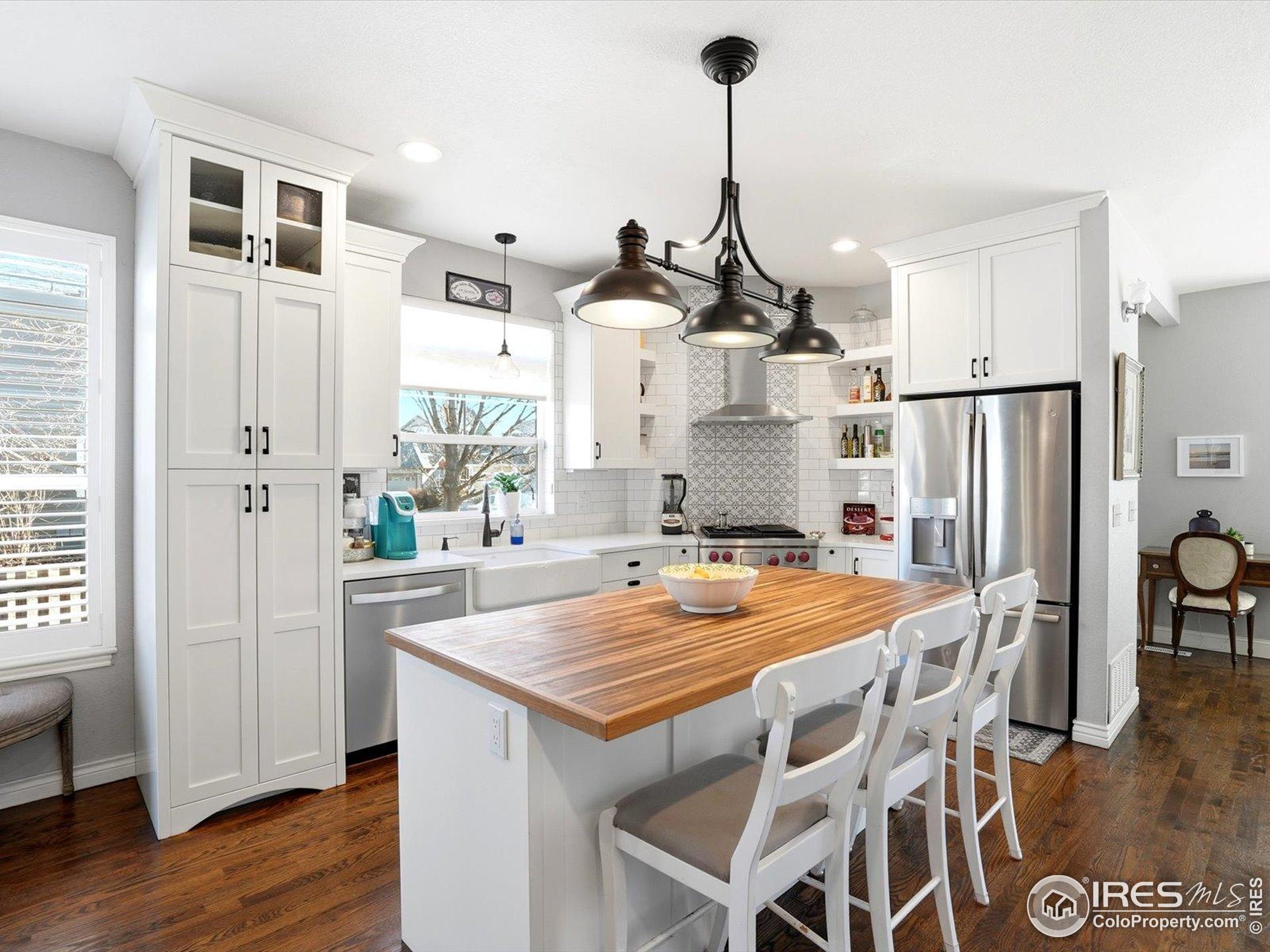 2139 Springs Place Longmont, CO 80504 - Photo 14 of 50 a kitchen with stainless steel appliances kitchen island granite countertop a refrigerator a sink dishwasher with a dining table and chairs
