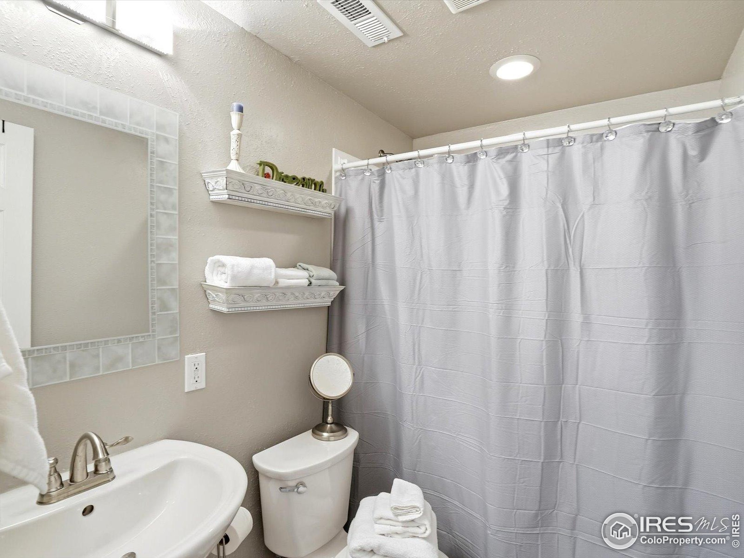 2139 Springs Place Longmont, CO 80504 - Photo 30 of 50 a bathroom with a sink a toilet and shower curtain