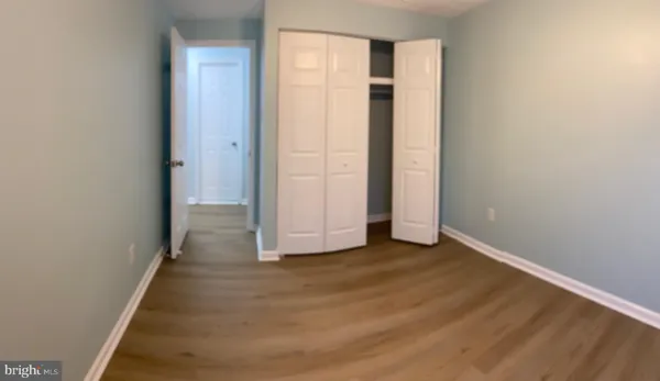 a view of a hallway with wooden floor and entryway